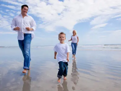 family running on the beach