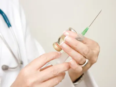 doctor with a needle and vial of medicine
