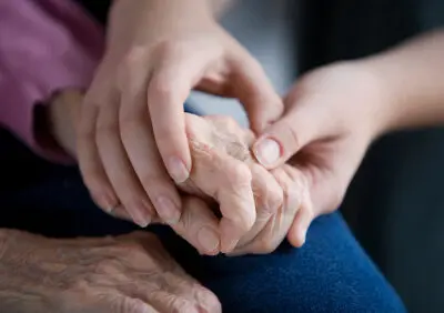 holding hands with an elderly person