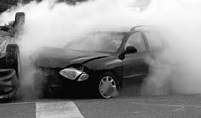 black car in an accident billowing smoke