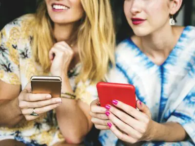 two smiling women with cell phones
