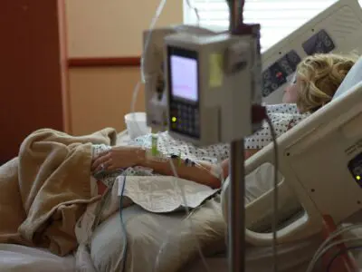 patient in hospital bed with IV monitors