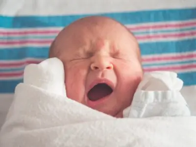 swaddled newborn baby crying