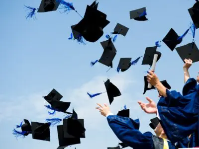 graduates throwing their caps into the air