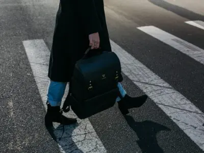 person with backpack walking through crosswalk