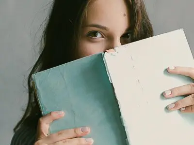 college student peering over book