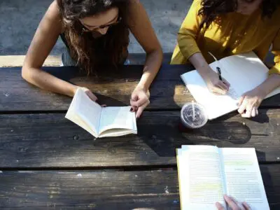 two students studying at a picnic table