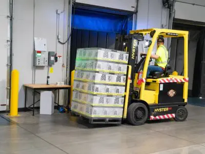 worker driving a yellow forklift