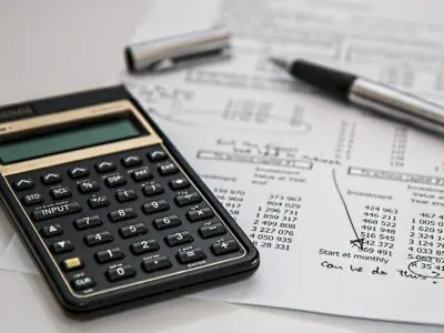 calculator with pen and insurance paperwork