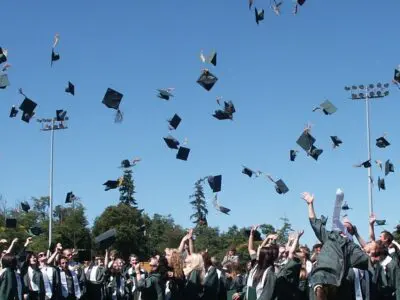 a group of graduates throwing their caps into the air
