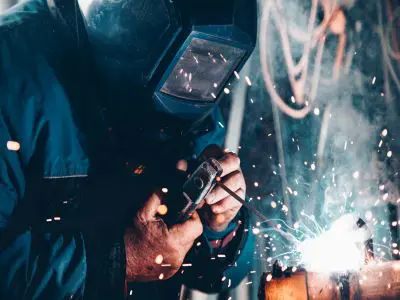 A welder wearing head protection while working.