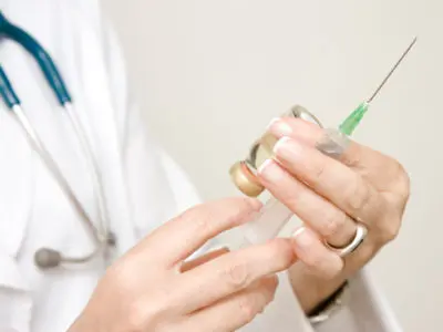 doctor with a needle and vial of medicine