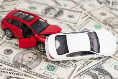 two wrecked toy cars sitting on cash