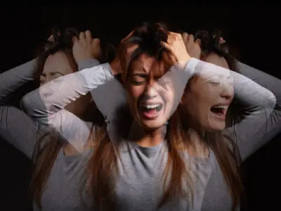 Shot of a young woman experiencing mental illness against a black background