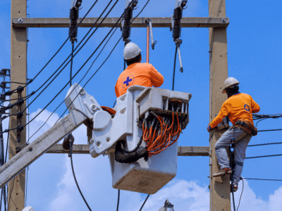 Utility workers repairing power lines on electric poles