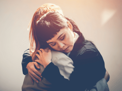 Two women hugging in a moment of emotional support and grief