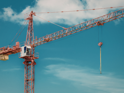 Tower crane at a construction site with suspended hook and rigging, illustrating the equipment involved in crane collapse and tip-over accidents and the safety risks that can lead to serious construction injuries in Atlanta.