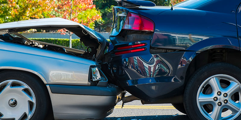 two cars with damage on a road after a crash